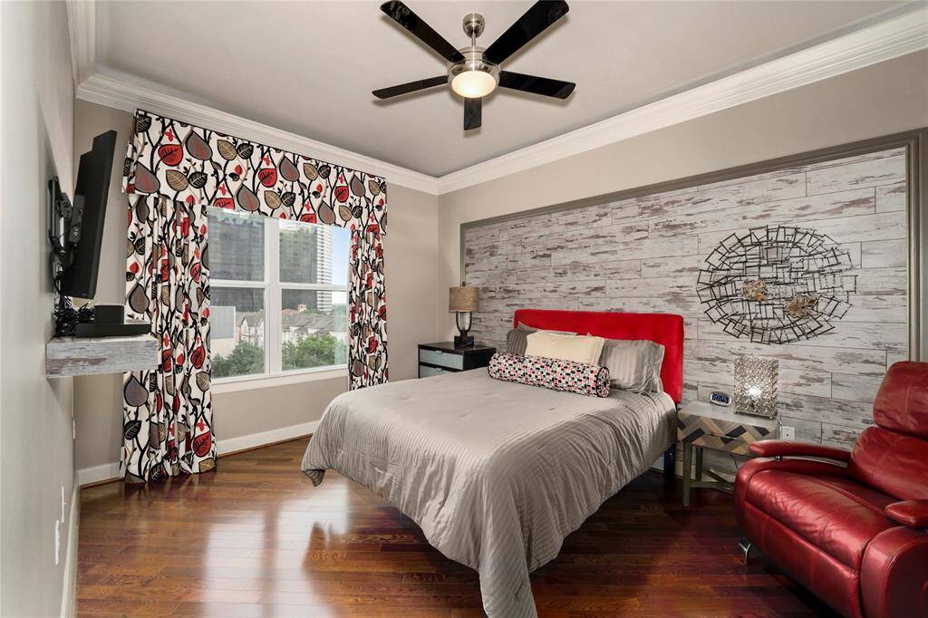 This is your primary bedroom with custom wall accent and custom curtains. Bedroom is spacious enough for chairs and other furniture.