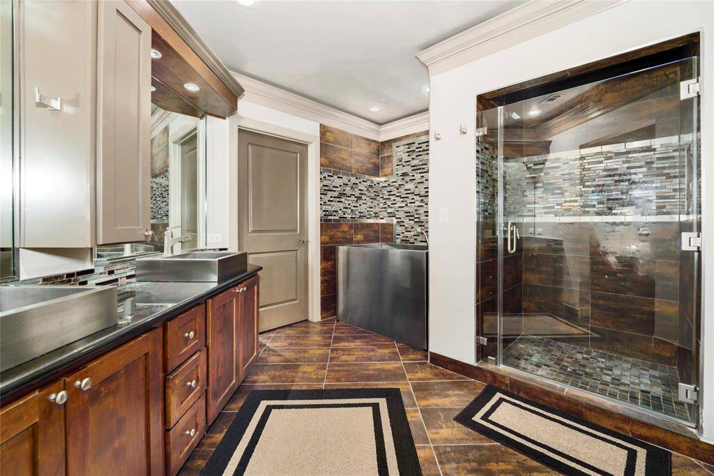 Dual vanities, stand-up shower, separate Japanese soaking tub, and walk-in closet in this bathroom.