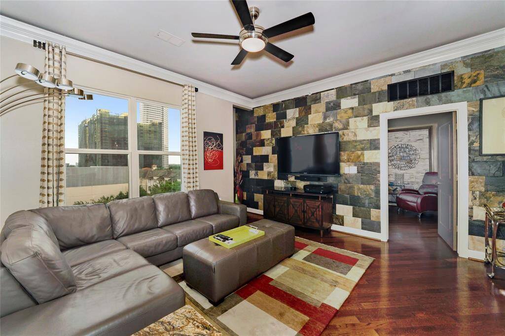 Another view of the living room space that's large enough for oversized sectionals. Ambient lighting between the crown molding and the ceiling.