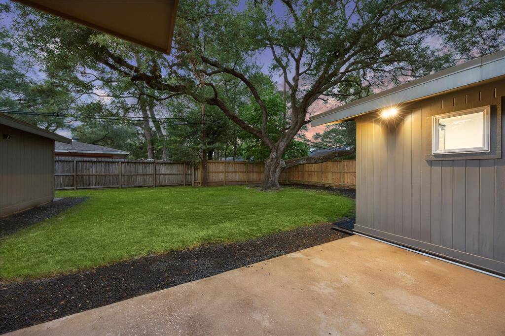 Pool size back yard with a mature oak tree for shade