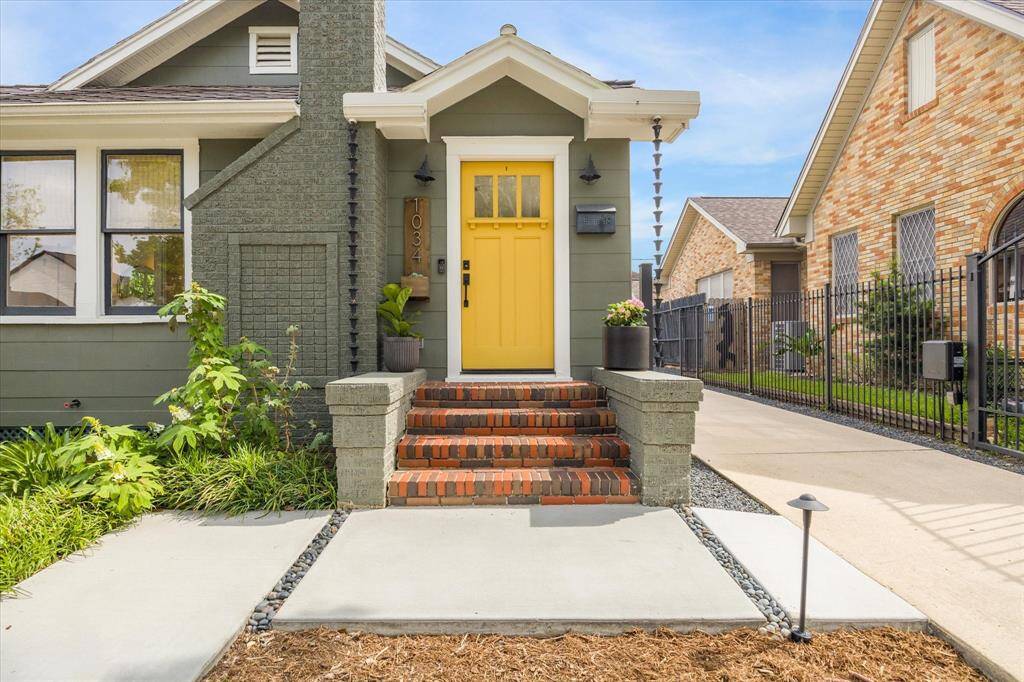 Charming home with a welcoming yellow front door and brick steps.