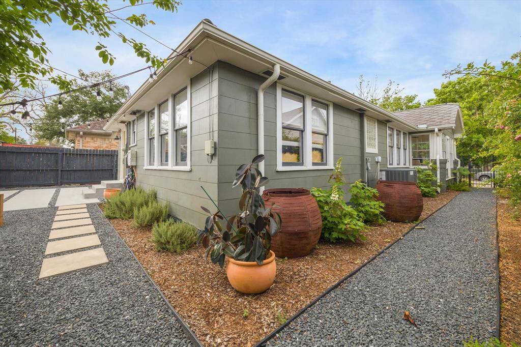 The yard is adorned with decorative planters and greenery, creating a welcoming outdoor space.