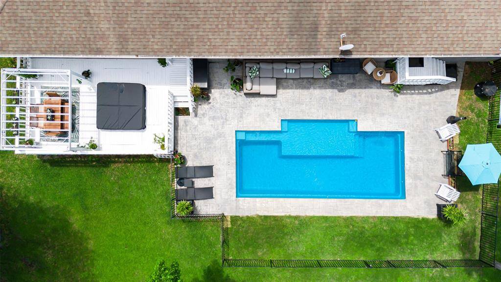 Outdoor entertainer’s paradise featuring new pool, inviting al fresco dining area, cool shaded patio, and relaxing hot tub — perfect for hosting or unwinding in style