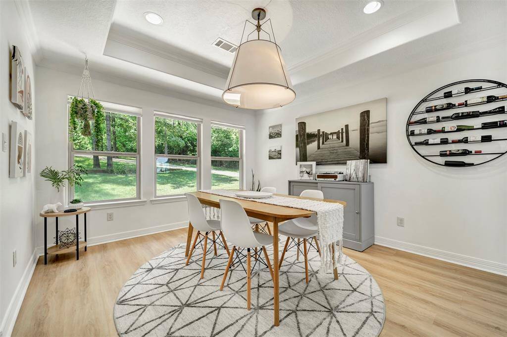Enjoy formal dining with a picturesque view overlooking the expansive front lawn, adorned with lush greenery and mature shade trees