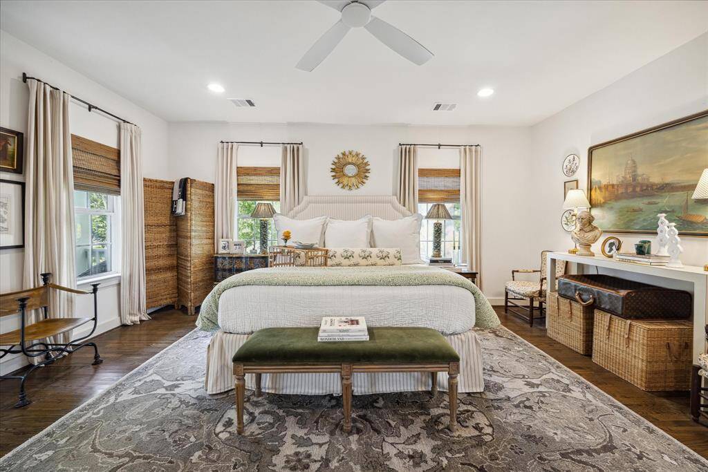 Windows are adorned with natural bamboo shades that beautifully complement those gleaming wood floors.