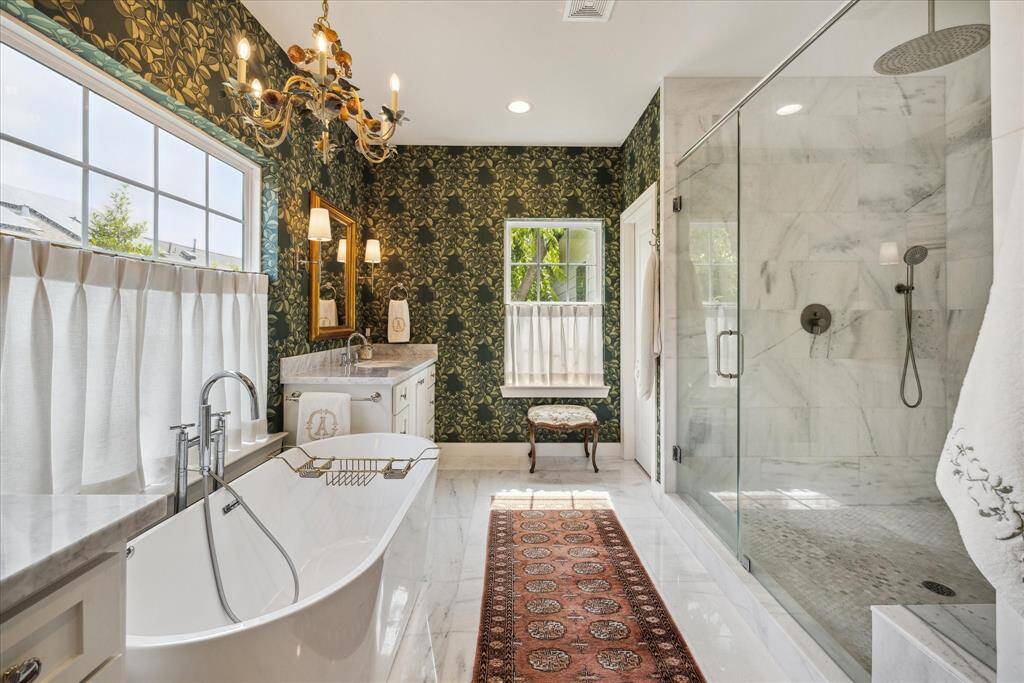 Indulge in tranquility with this primary bathroom showcasing magazine-worthy finishes.  The luxurious rain shower promises a spa-like experience right at home.