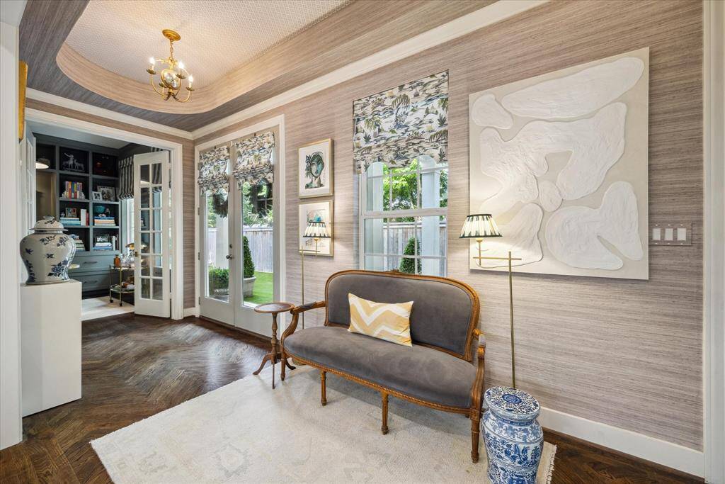 Upon entering, you will be welcomed by this superb entryway with herringbone floor detail, walls showcasing Thibaut Grasscloth wallpaper, beautifully complemented with Thibaut wallpaper on the ceiling, visual comfort light fixtures and custom roman shades on the windows and doors.