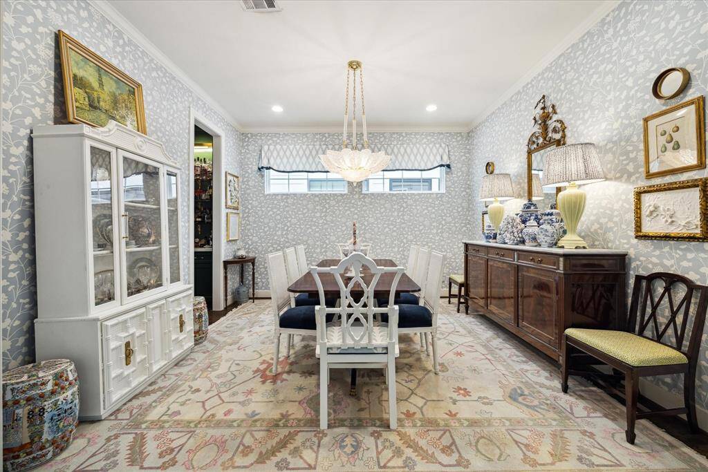 Imagine hosting memorable dinners in the formal dining room. It showcases Schumacher wallpaper with perfectly coordinated custom Schumacher fabric window treatments. Dining room has convenient access to the kitchen through the dry bar, doorway to the left. Note: The chandelier has been replaced with a beautiful Visual Comfort Chandelier (not pictured).
