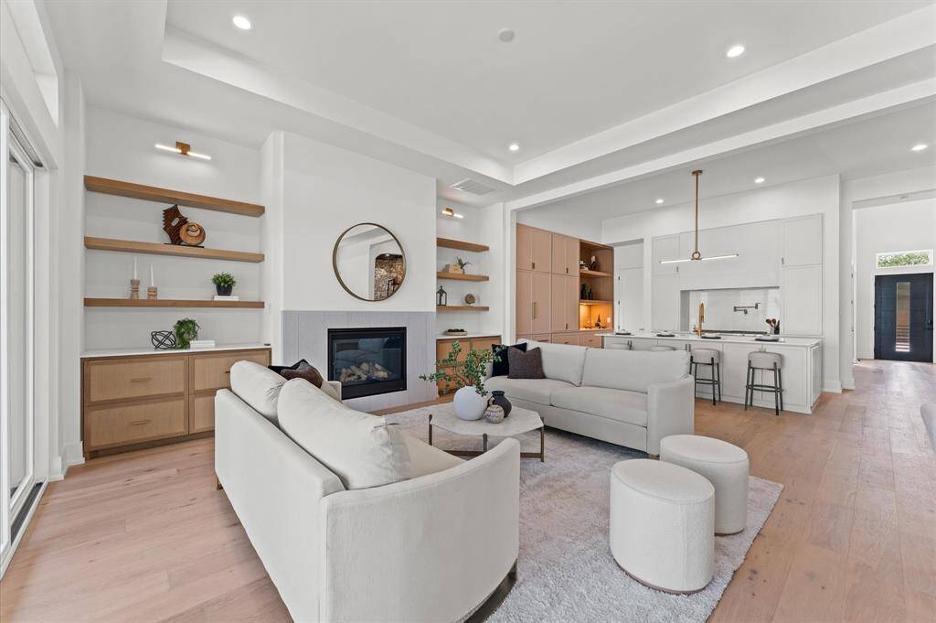 Great room has shelving and built in storage on both sides of the fireplace.