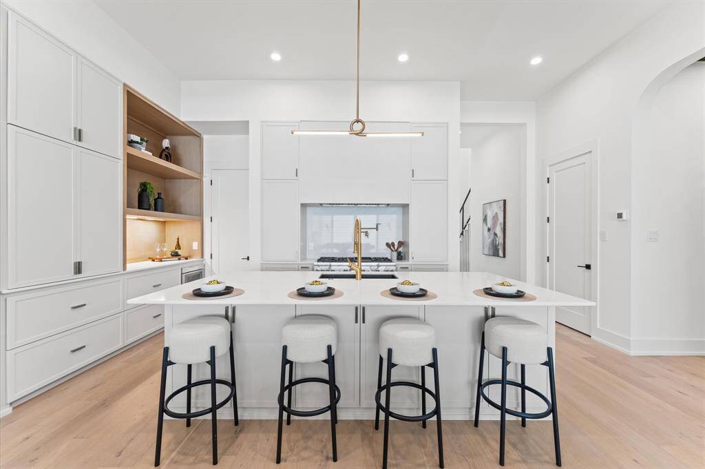 Kitchen is finished with custom cabinetry and a coffee bar with recessed doors.
