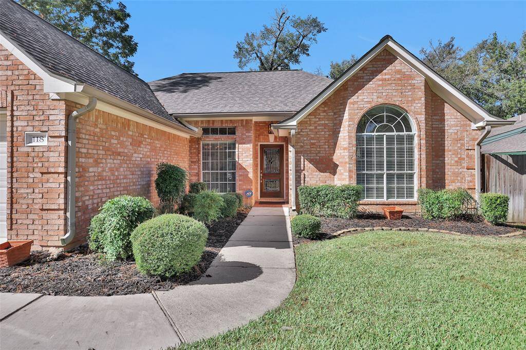 This is a well-maintained single-story brick home featuring a gabled entry, large arched window, and manicured landscaping.