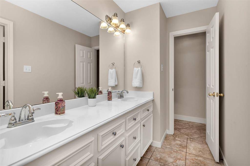 Dual sinks enhance convenience in the secondary bathroom.