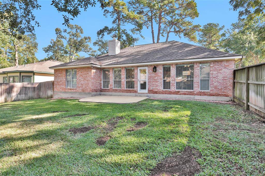 This is a single-story brick home featuring a well-maintained lawn, a cozy backyard with privacy fencing, and ample natural light from several windows. The home has a traditional design with a shingled roof and an inviting atmosphere.