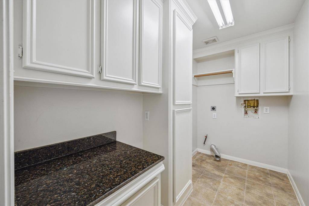An oversized laundry area with counter space and ample storage.