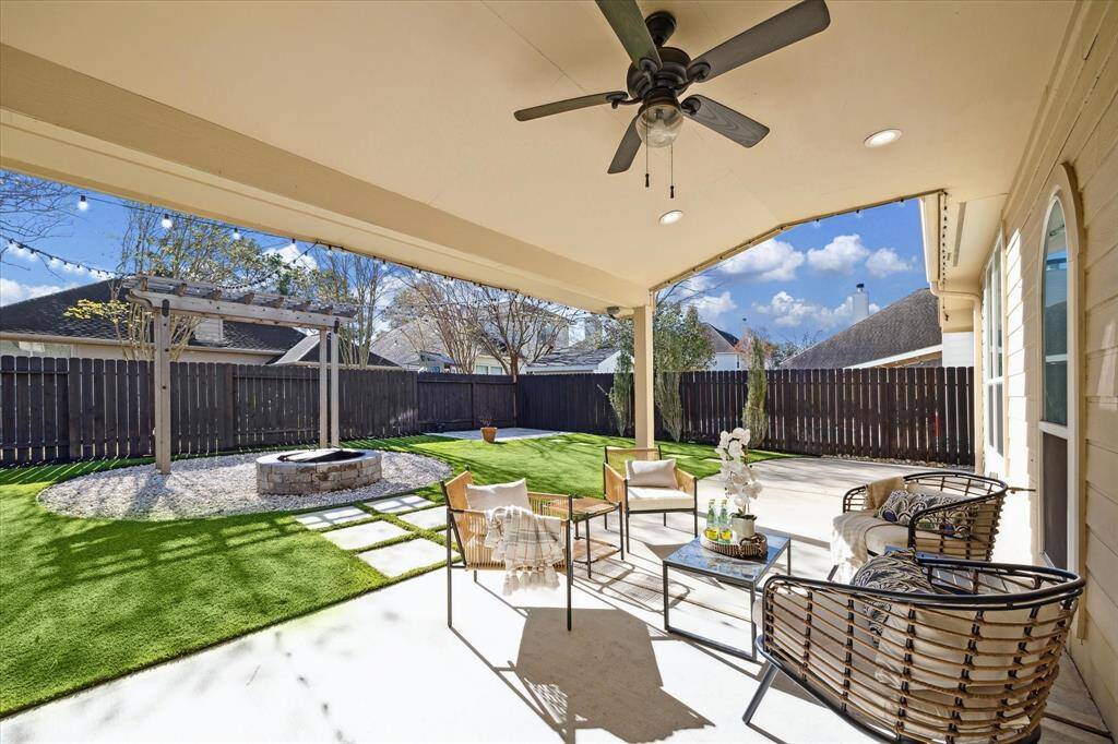 An oversized covered back patio with an overhead fan to escape the sun and heat.