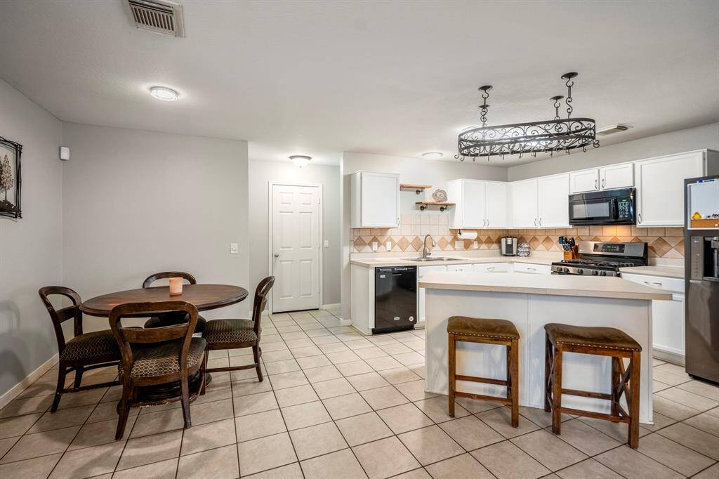 This contemporary kitchen boasts sleek white cabinetry and modern appliances.
