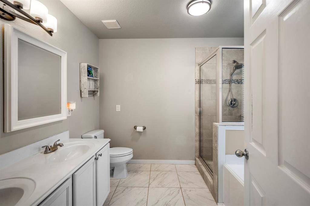 Welcome to the tranquil primary bathroom, featuring neutral walls and natural lighting from a large window.