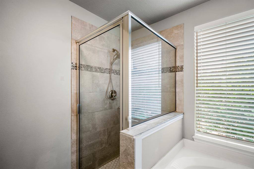 The clear glass door and contemporary fixtures add a touch of luxury.