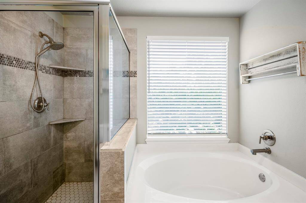Relax in this luxurious bathroom corner with a separate tub and shower.
