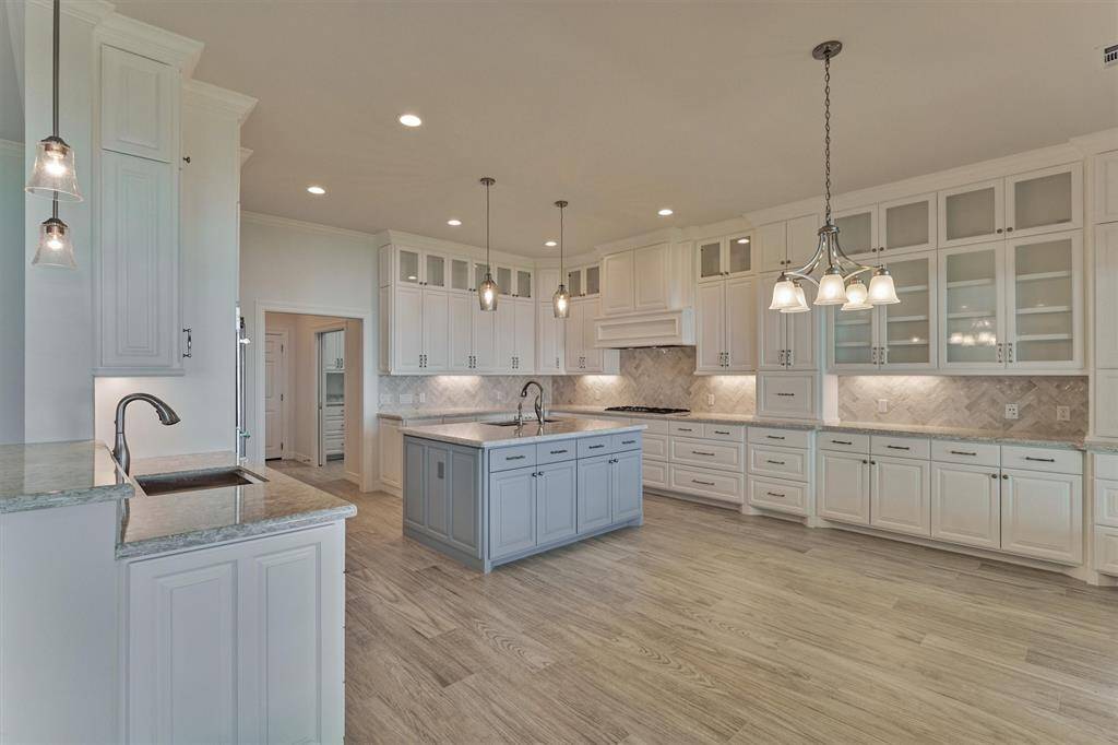 The kitchen and dining area were thoughtfully designed to combine functionality with style. Two sinks provide added convenience, while a mix of glass-front and solid cabinetry, along with an array of drawers, offers versatile and abundant storage options.