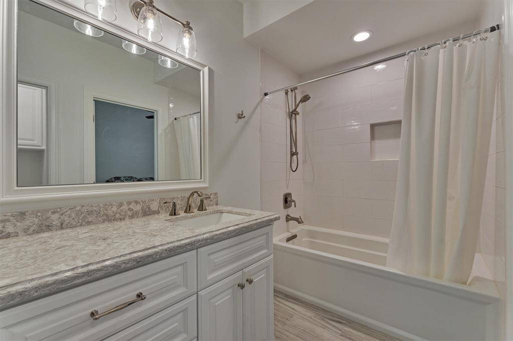 A full bath on the first floor features an oversized soaking tub by Kohler, (32x66x19), elegant quartz countertops, and stylish lighting.