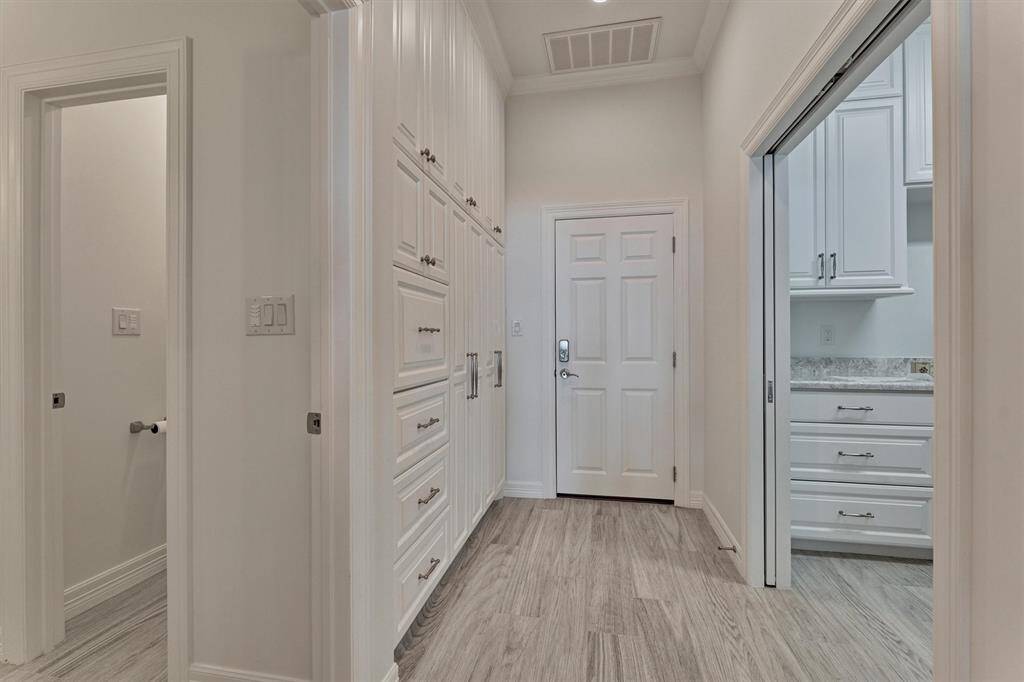 Every inch of this home was thoughtfully utilized, including the hallway off the garage. Custom cabinets and drawers provide discreet storage for mudroom essentials, keeping the space organized and clutter-free while maintaining a polished look.