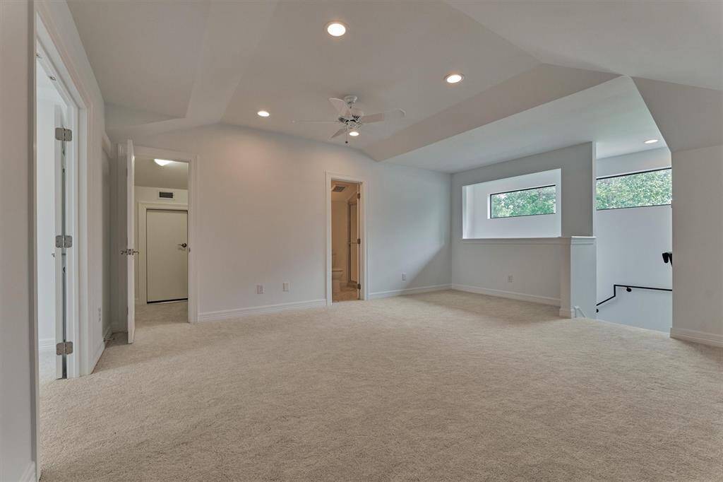 From another angle, the bonus space reveals a thoughtfully designed wall cut-out that allows natural light to flow in, creating a bright and inviting atmosphere. Just beyond, you'll find a full bath and closet, enhancing the functionality and comfort of this private upstairs retreat.