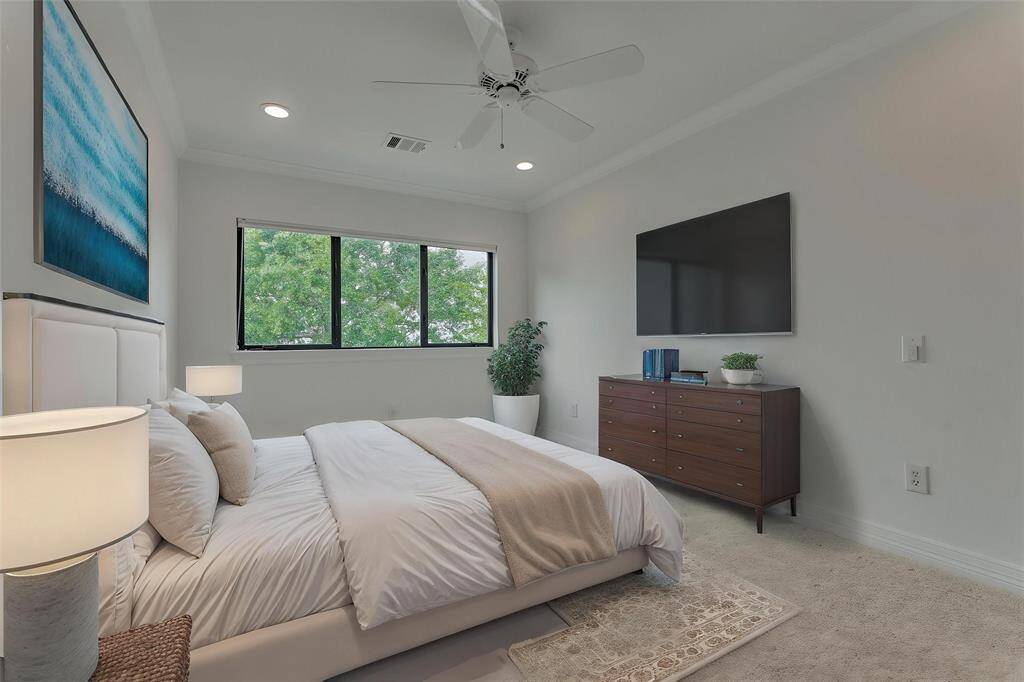 This additional room in the upstairs suite features a large window that fills the space with natural light and offers serene views of the mature trees in the backyard and the sparkling lake beyond. Photo has been virtually staged to show furniture placement.