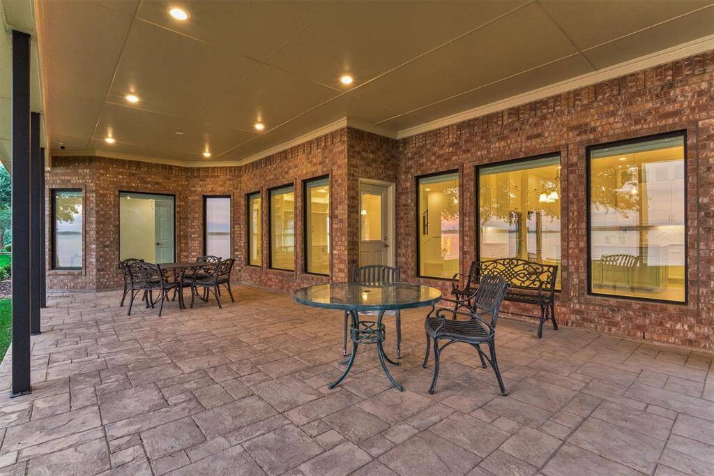 The spacious back porch easily accommodates multiple seating areas, making it ideal for gatherings and entertaining. High-end picture windows feature a low U-factor and tinted glass for optimal energy efficiency. Additionally, the porch is pre-plumbed with a gas line, ready for a future outdoor kitchen installation.