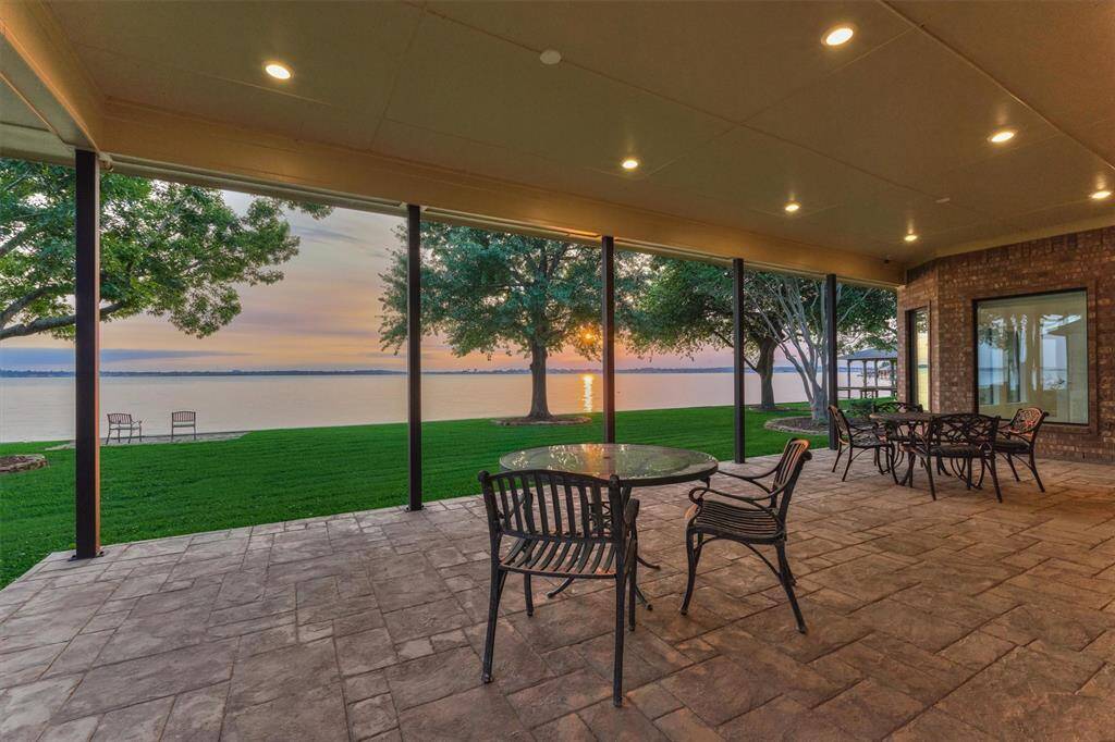 The expansive back porch was thoughtfully crafted with stamped, colored concrete for added visual appeal and durability. LED recessed lighting enhances evening ambiance, while sturdy 4" steel tube columns are in place, ready to accommodate future screens or glass enclosures, if desired.