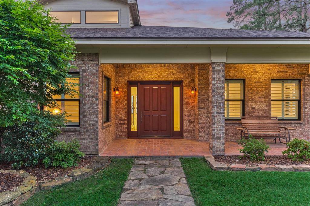 The original 4' x 7' solid wood door was carefully refinished and preserved, adding a distinctive, character-rich touch to the home. The covered front entry is enhanced by classic brick flooring and beautifully landscaped beds bordered with stone edging.