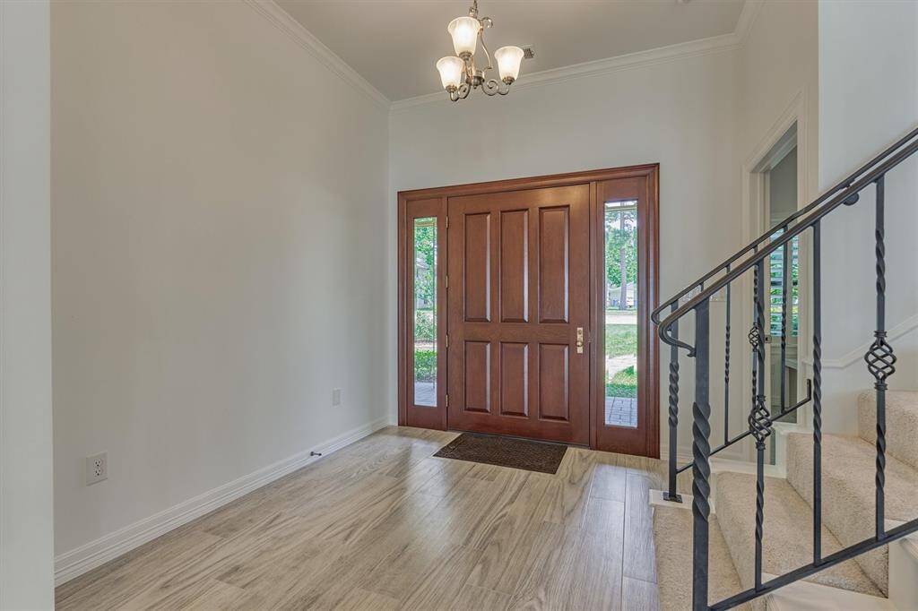 The entry door is flanked by two glass sidelights, allowing natural light to stream in and creating a bright, open, and inviting atmosphere.