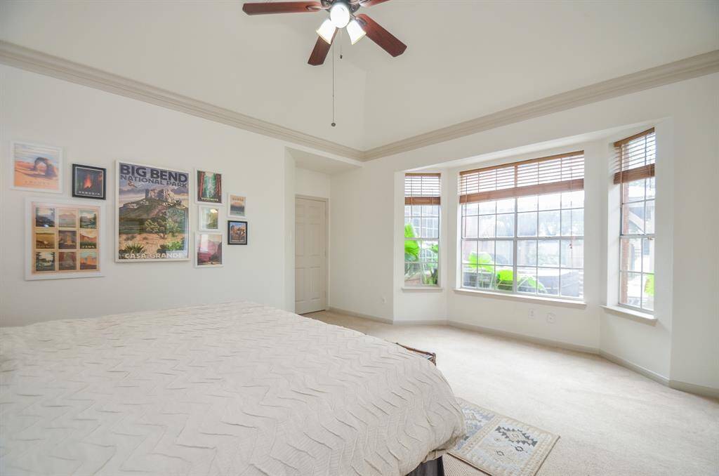 This is a bright and airy bedroom featuring ample natural light from two large windows