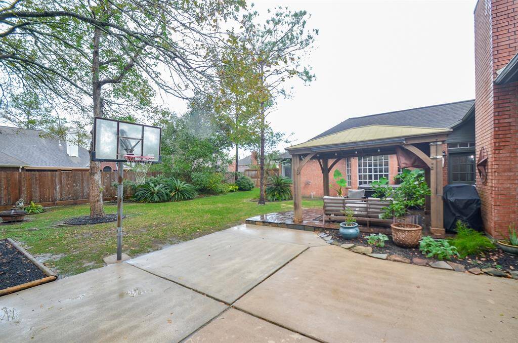 This photo showcases a cozy backyard with a covered patio area, perfect for outdoor dining or lounging.