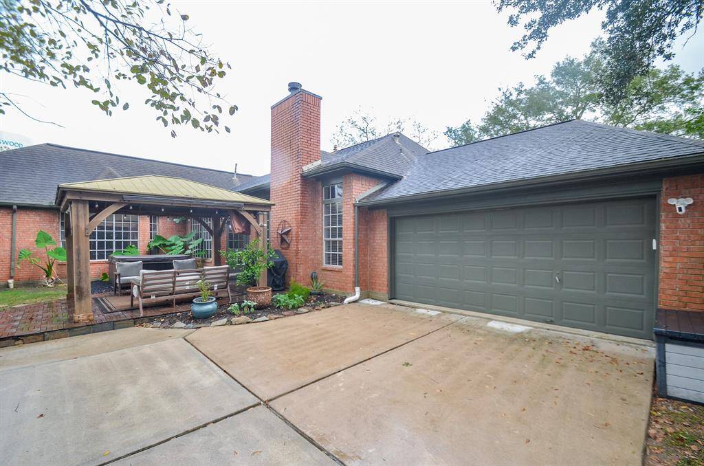 This is a single-story brick home featuring an attached two-car garage and a cozy covered patio area