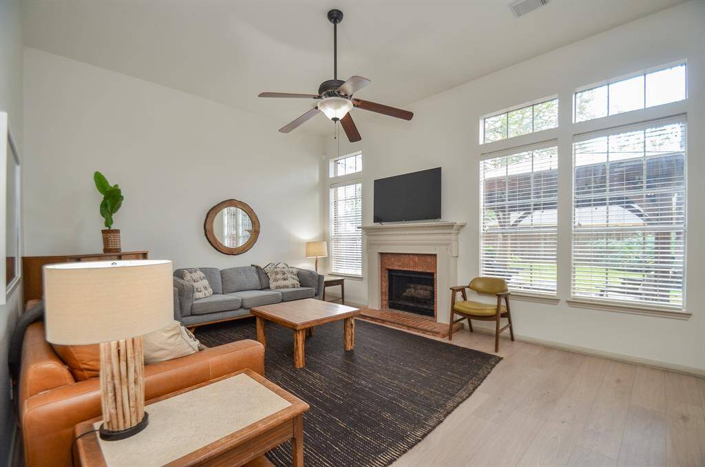 This is a spacious living room featuring  a cozy fireplace, and luxury vinyl plank floors.