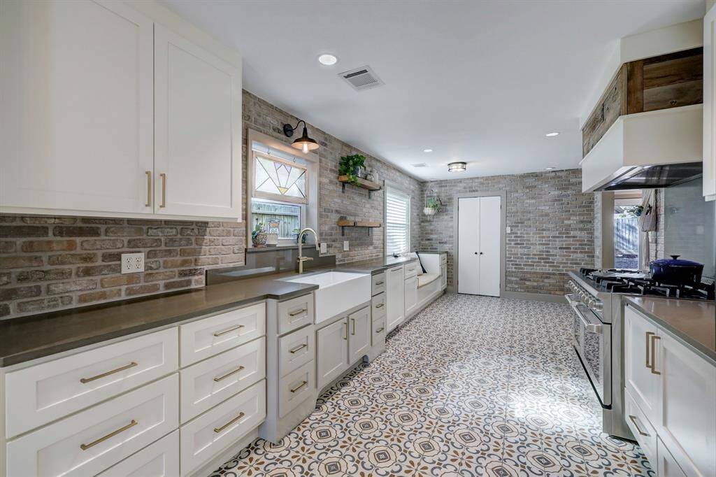 Kitchen includes a soft brick backsplash that adds a rustic character to the space.