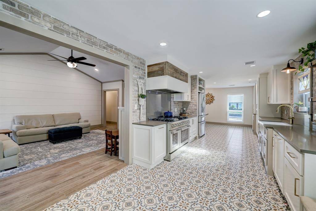 Notice the distance of the vent hood and the gas range, giving plenty of space for taller pots, while adding to the aesthetic with the touch of reclaimed ship lap.