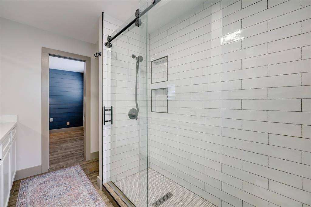 Modern and spacious standing shower with timeless subway and penny tile.