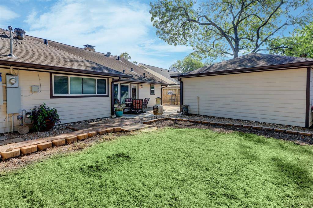 Back of the home offers a patio that seamlessly extends to a spacious yard.
