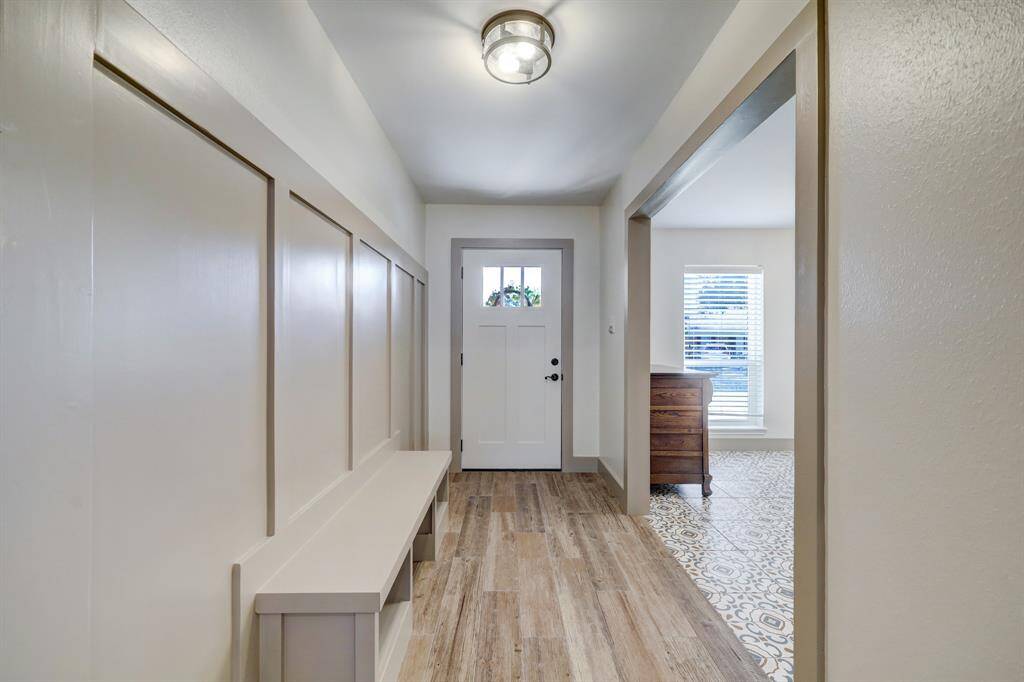 Elegant custom carpentry enhances the walls, while the bench cleverly hides shoe cubbies.