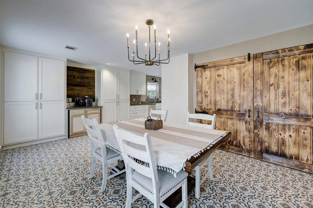Experience modern farmhouse elegance in the dining room, featuring stunning barn doors leading to the pantry or additional storage.
