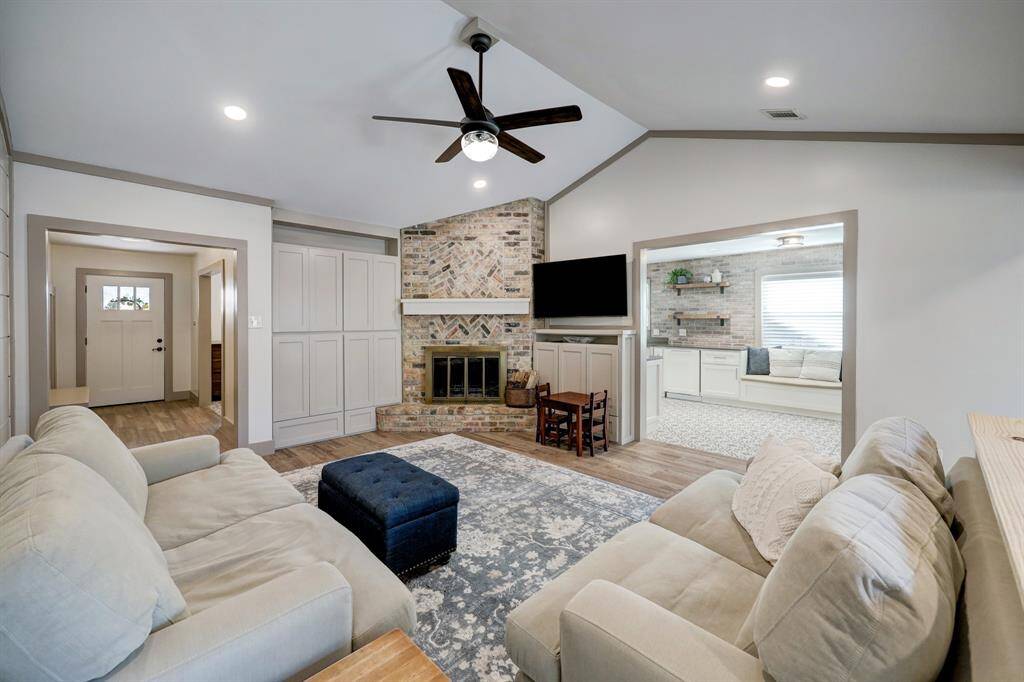 Cozy living room featuring ample storage and a burning wood charming fireplace. High ceilings and custom woodwork.