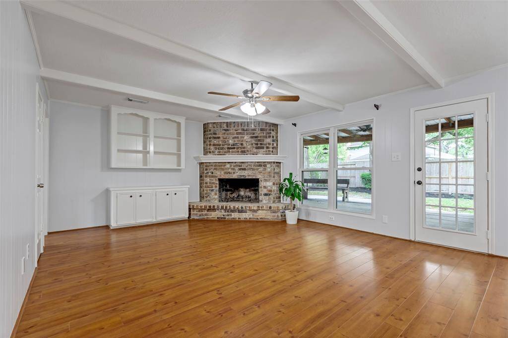 Spacious living room with gas fireplace and big windows with natural light