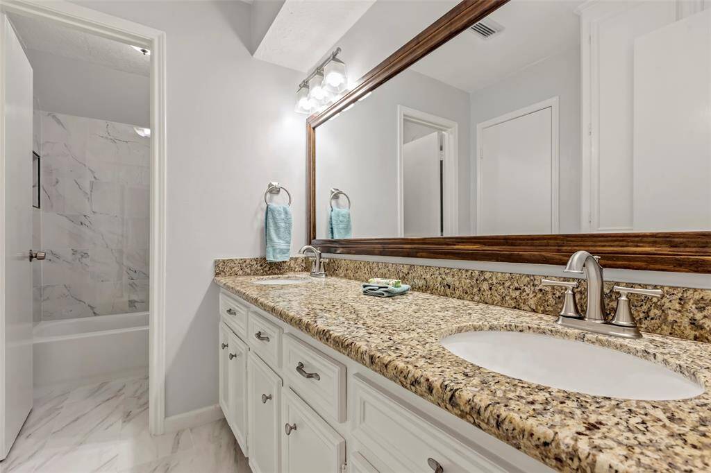 Secondary bathroom with double sinks and new shower.