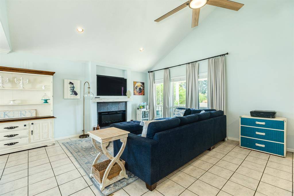 Upstairs living room has tile floors, an electric fireplace with windows looking out towards the canal.