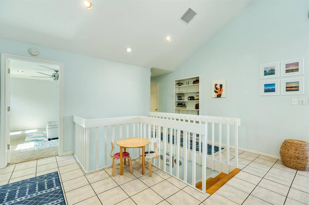 In view, to the left is the entry way to the primary bedroom and to the right is the hallway leading to the powder & utility rooms.