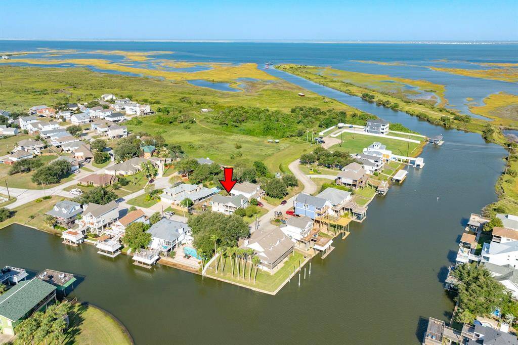Aerial view of home showing location in the subdivision & main canal leading out to West Galveston bay.