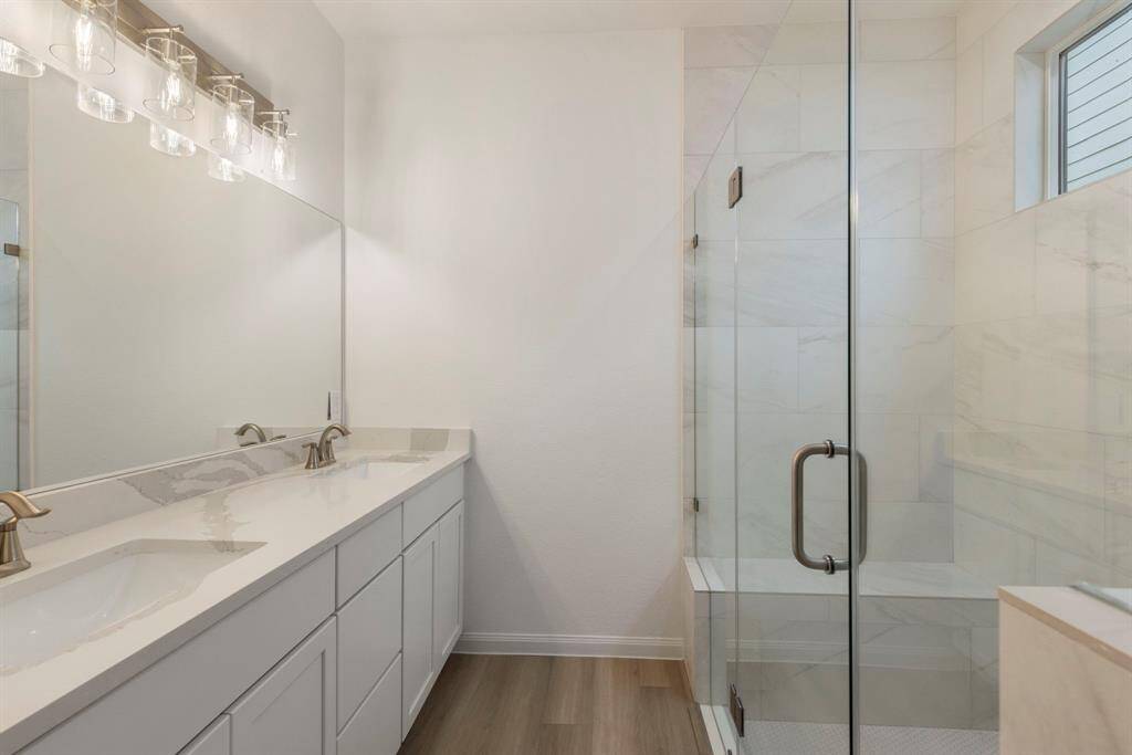 Primary bath with dual sinks and large walk in shower.