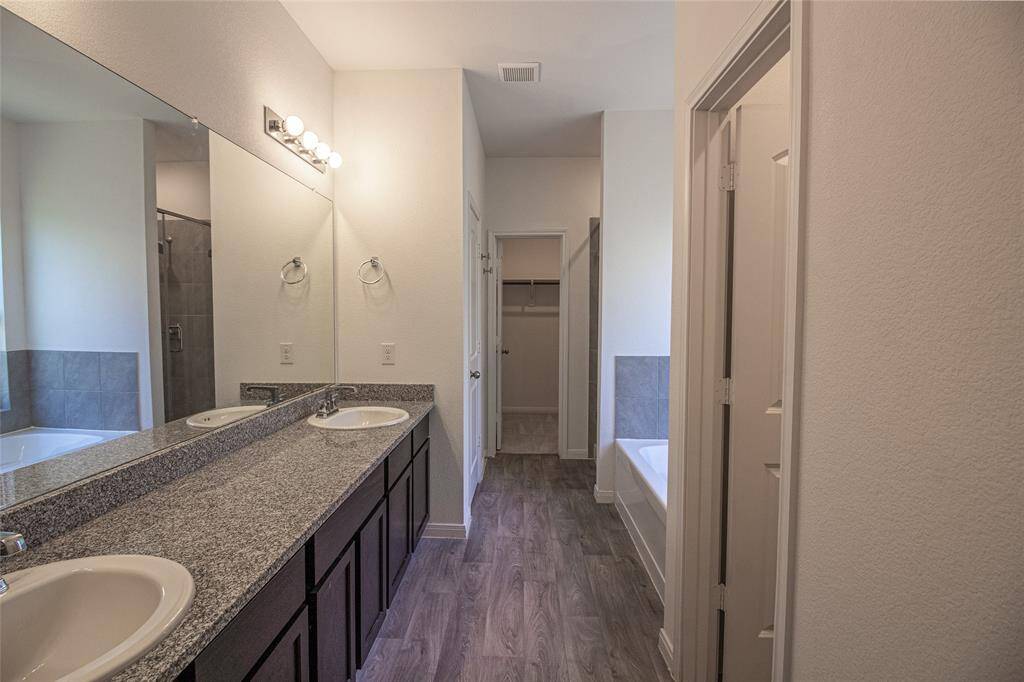 Lovely primary bath with dual sinks, tub, and shower...